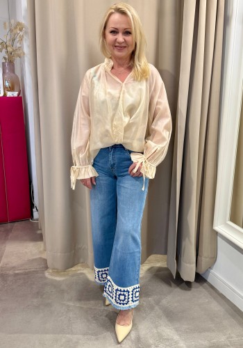 Spodnie jeansowe w wakacyjnym klimacie. nogawki zakończone haftami kremowo-niebieskimi w letni motyw wzór.